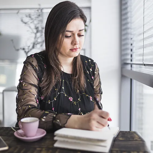 Persona escribiendo en un diario