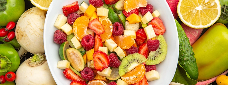 Plato lleno de frutas y verduras frescas, variadas y coloridas.
