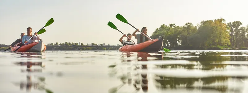 Familia disfrutando de un paseo en kayak en un lago | Family enjoying a kayak ride on a lake.