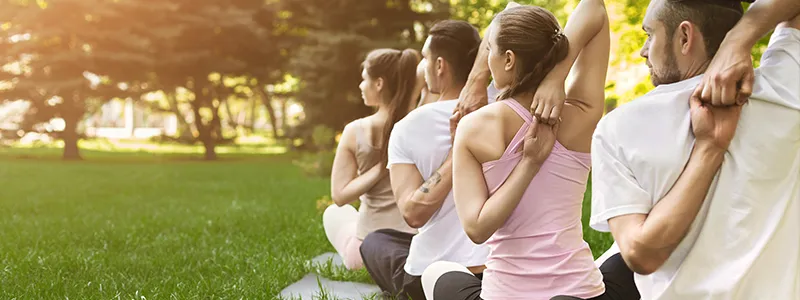 Group of people practicing yoga in a park