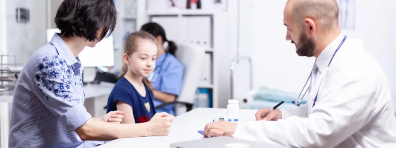 Doctor performing a physical exam on a child at Dr. GoodPrice Clinic.