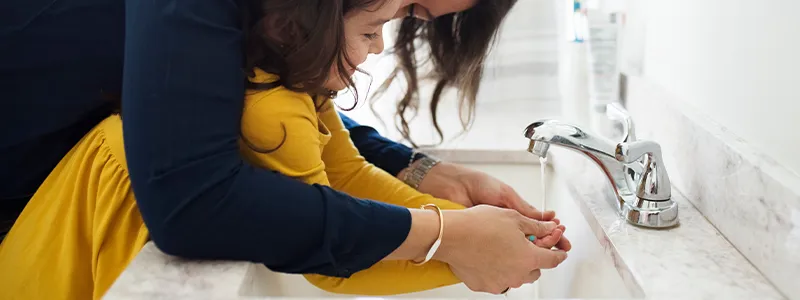 Family washing hands to prevent illness,