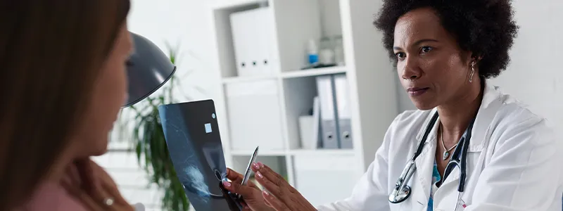 Woman receiving a mammogram to detect signs of breast cancer.