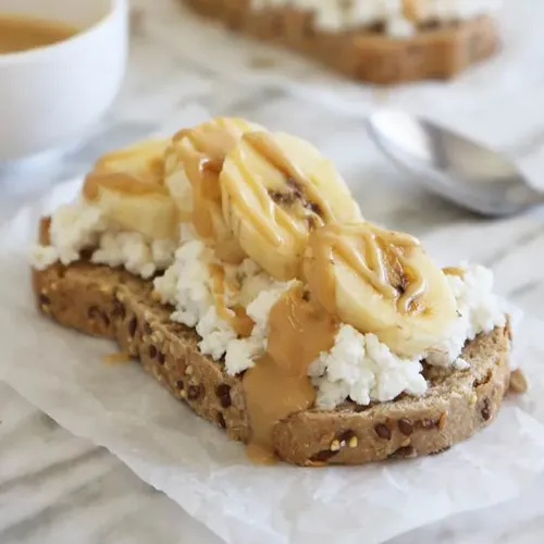 Requesón con mantequilla de maní y plátano, un postre alto en proteínas y de digestión lenta.