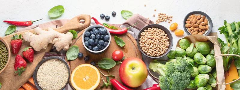 Alimentos saludables y agua en la mesa, promoviendo una dieta equilibrada.