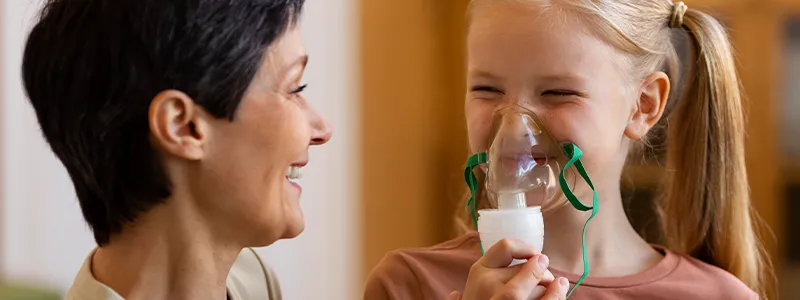 Child using a rescue inhaler to manage asthma symptoms. Importance of adhering to treatment.