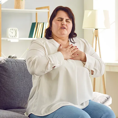 Woman with chest pain, a possible heart attack symptom.