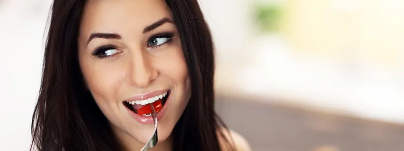 Persona feliz comiendo ensalada con pollo y lentejas